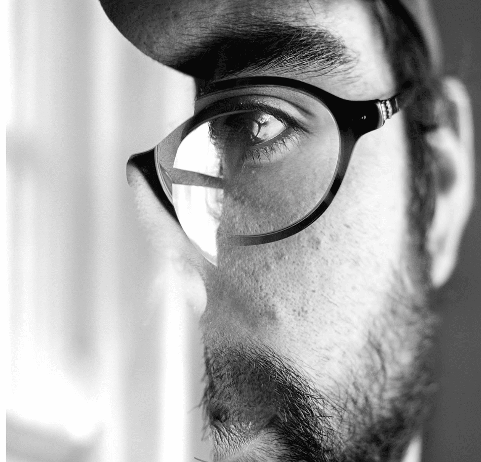 Clément with round glasses, contemplative