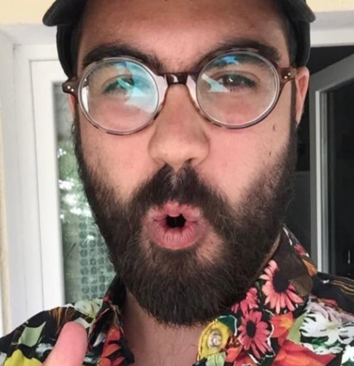 Clément in a hawaiian shirt with round tortoiseshell glasses