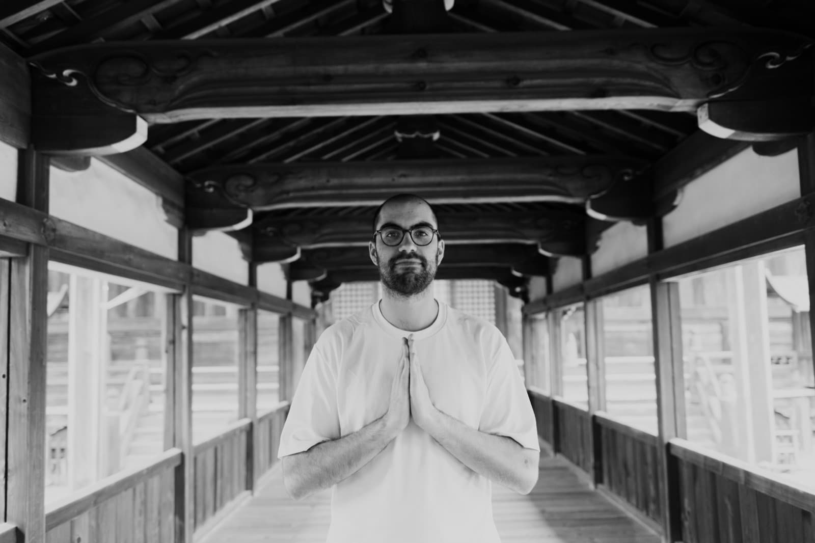 Clément Dourlens, hands in prayer, in a wooden corridor